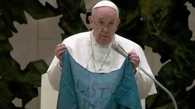 Pope Francis holds up and kisses Ukrainian flag from Bucha